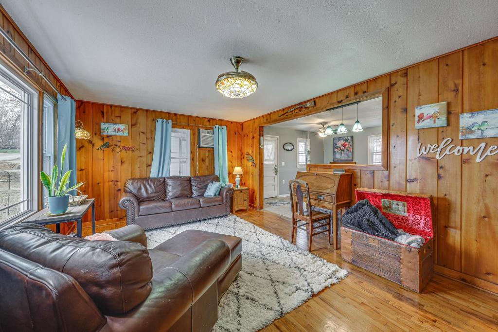 uma sala de estar com mobiliário de couro e paredes de madeira em Lecompton Vacation Rental about 10 Mi to Clinton Lake! em Lecompton