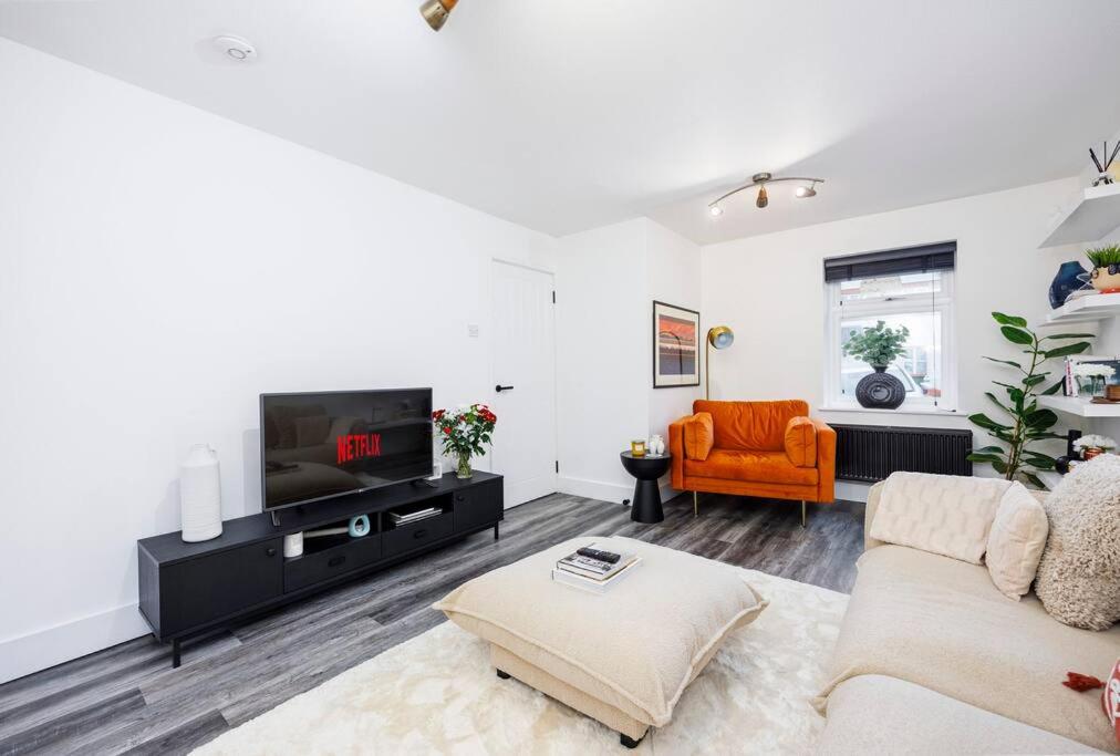 a living room with a couch and a tv at Stylish 2-Bed East London Home Contractors Parking Sleeps 5 Near ExCeL London in London