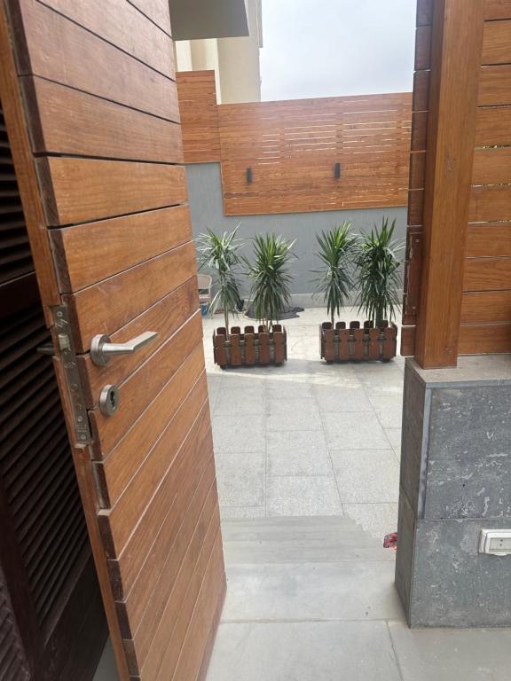 Oriana Villa Guest House في القاهرة: باب خشبي في مبنى به نباتات الفخار