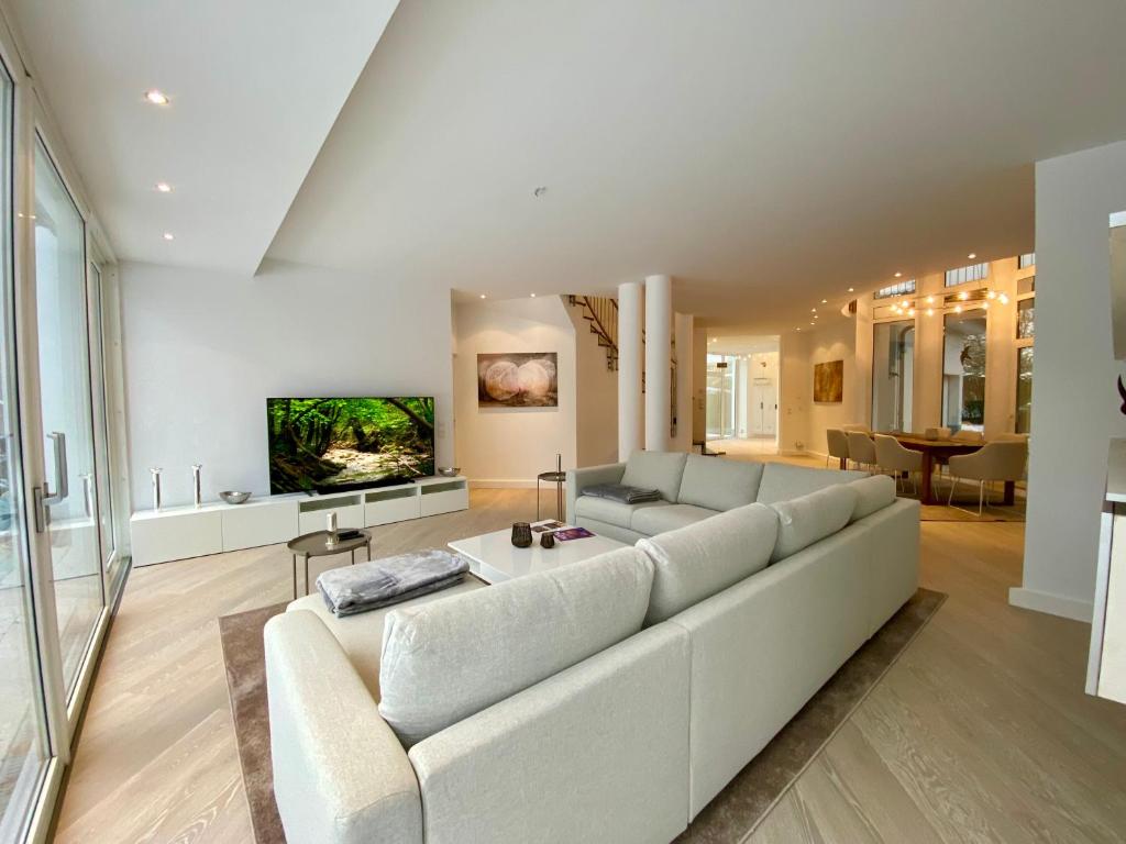 uma sala de estar com um sofá branco e uma televisão em Luxuriöse Villa zwischen Hannover und Hildesheim em Nordstemmen