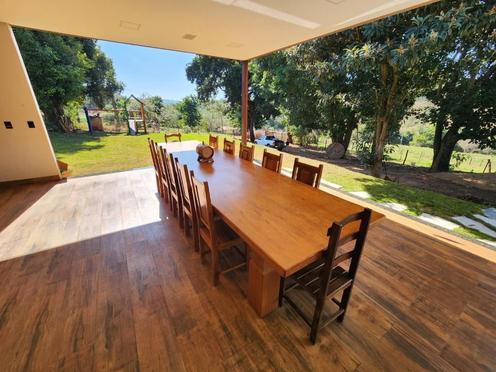 een grote houten tafel en stoelen op een patio bij Condado Rosa & Duarte in Piuí