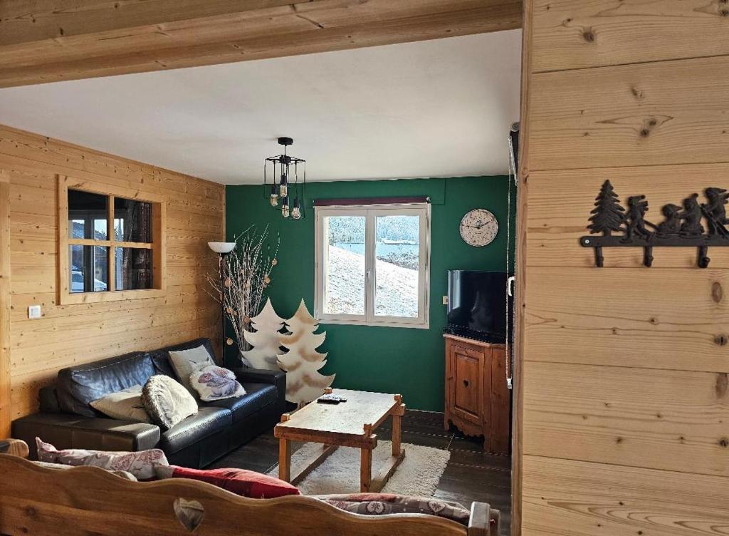 una sala de estar con sofá y árboles de Navidad en Appartement cosy, esprit montagne, au cœur du village en Chapelle-des-Bois