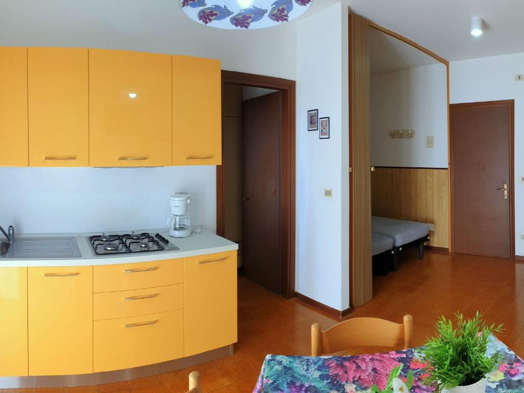 una cucina con armadi gialli e un piano cottura in una stanza di Residence Valbella Beach a Bibione