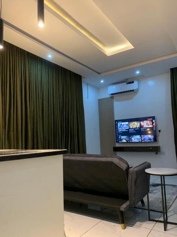 a waiting room with a couch and a flat screen tv at Luxury apartments in Ibadan