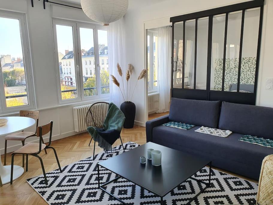 Suite Forum Vue Imprenable في رانس: غرفة معيشة مع أريكة زرقاء وطاولة