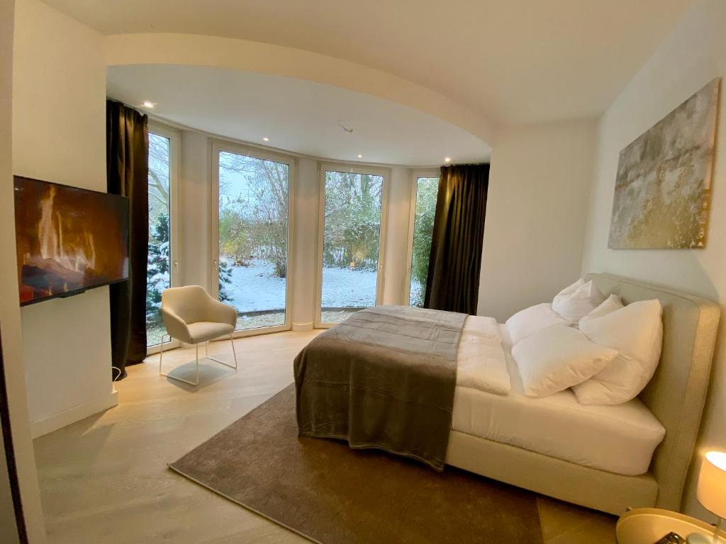 - une chambre avec un lit, une chaise et des fenêtres dans l'établissement Villa Vincent nahe Hannover, Hildesheim, Messe, à Nordstemmen