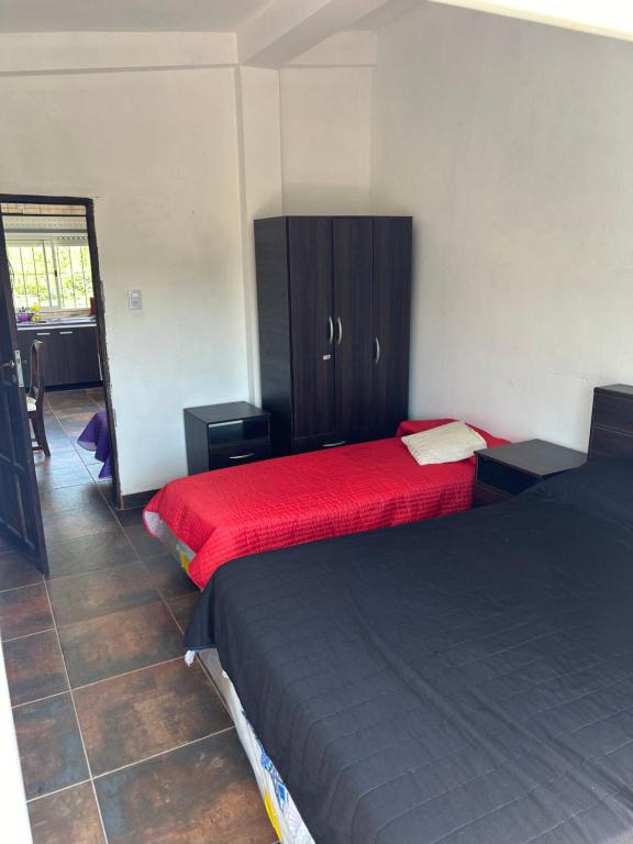 1 dormitorio con 2 camas y armario con sábanas rojas en KSA KMPO en El Carmen