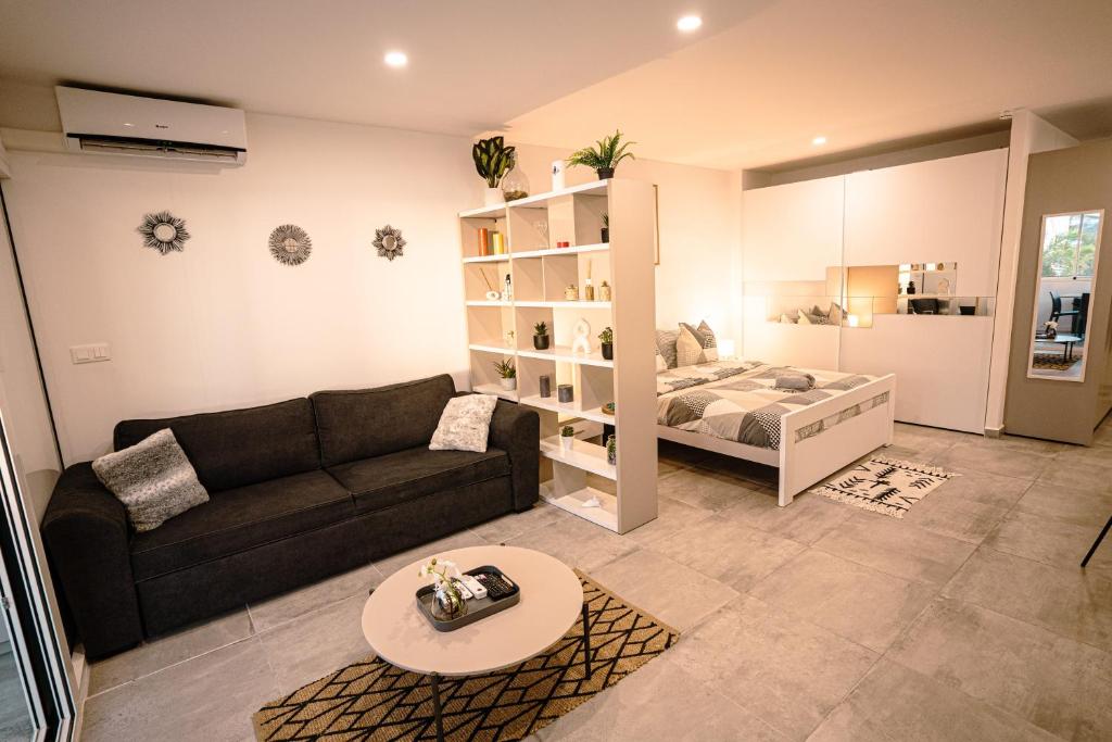 uma sala de estar com um sofá e uma cama em Merveilleux studio cosy vue mer - piscine em São Martinho