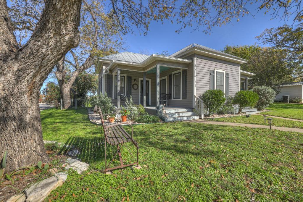 a small house with a tree in the yard at Austin Haus in Fredericksburg