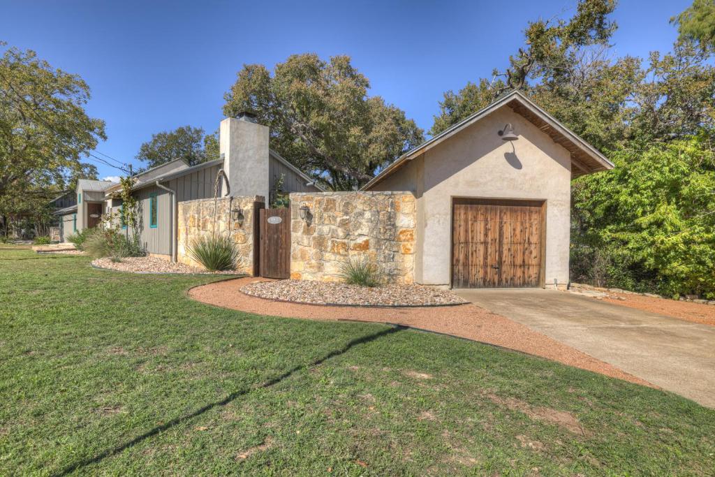 a house with a stone wall and a garage at 406 Lodge-A: Hot-Tub & 2 Blks to Main St in Fredericksburg