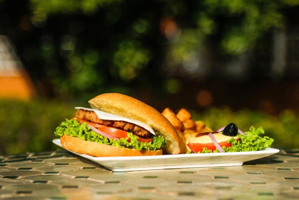 a sandwich and french fries on a plate on a table at Complexe El Bassatine in Beni Mellal
