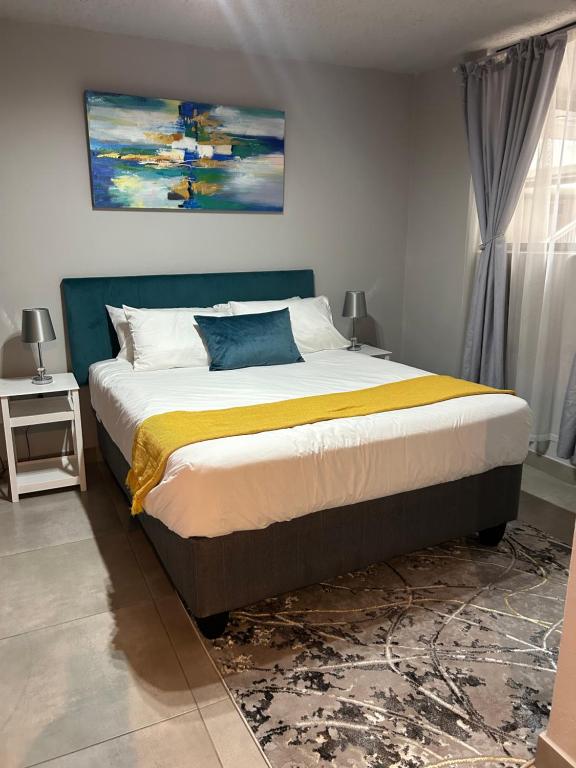 a bedroom with a bed with a painting on the wall at Circa Apartment 86 in Pretoria