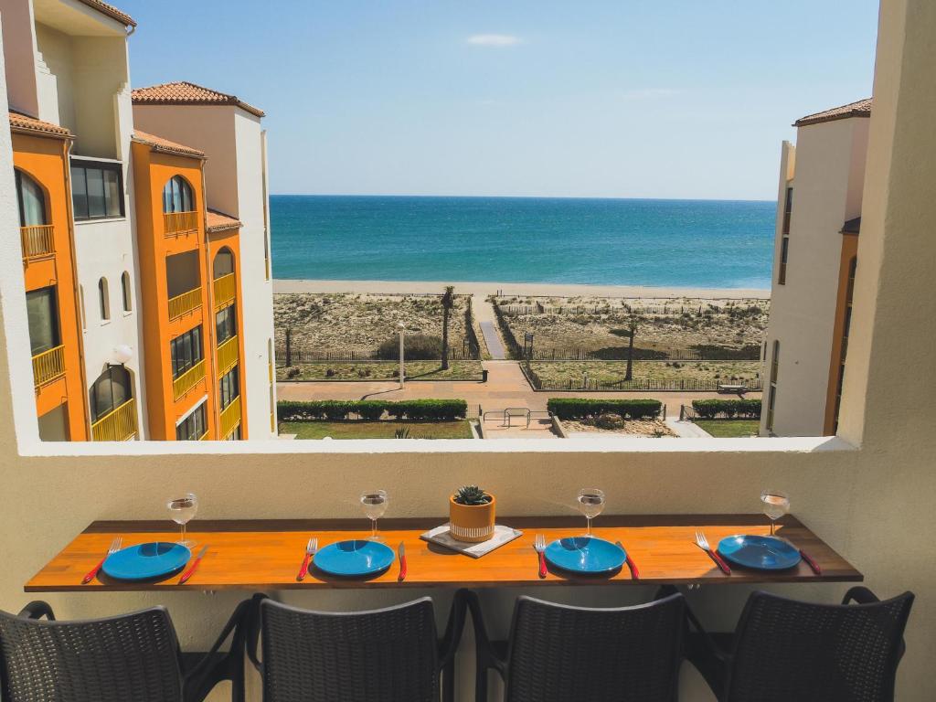 a table with a view of the ocean from a window at Superbe appartement vu mer avec parking et Wifi in Le Barcarès