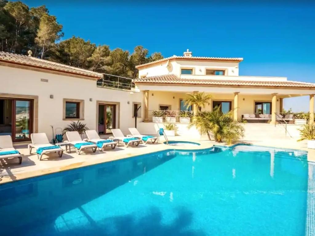 a villa with a swimming pool and a house at Casa Orquídea in Jávea