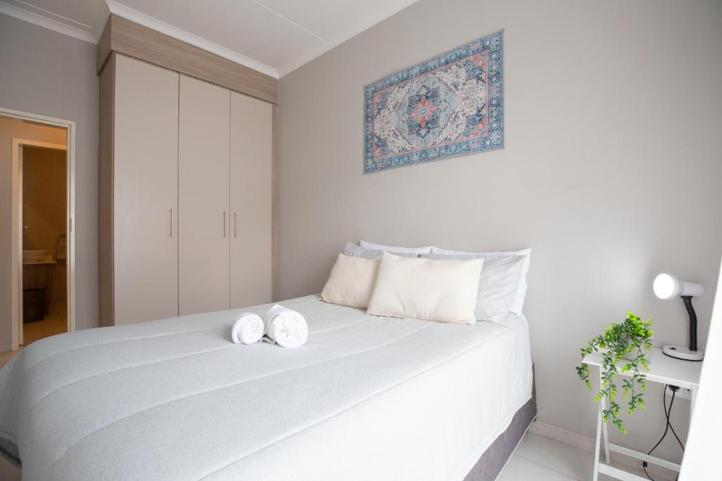 a bedroom with a white bed with two white pillows at Evergreen On Lever in Midrand