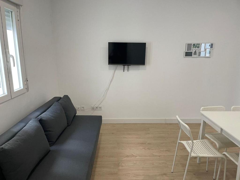 uma sala de estar com um sofá e uma televisão na parede em U4 Apartamento a estrenar, centro Madrid em Madrid