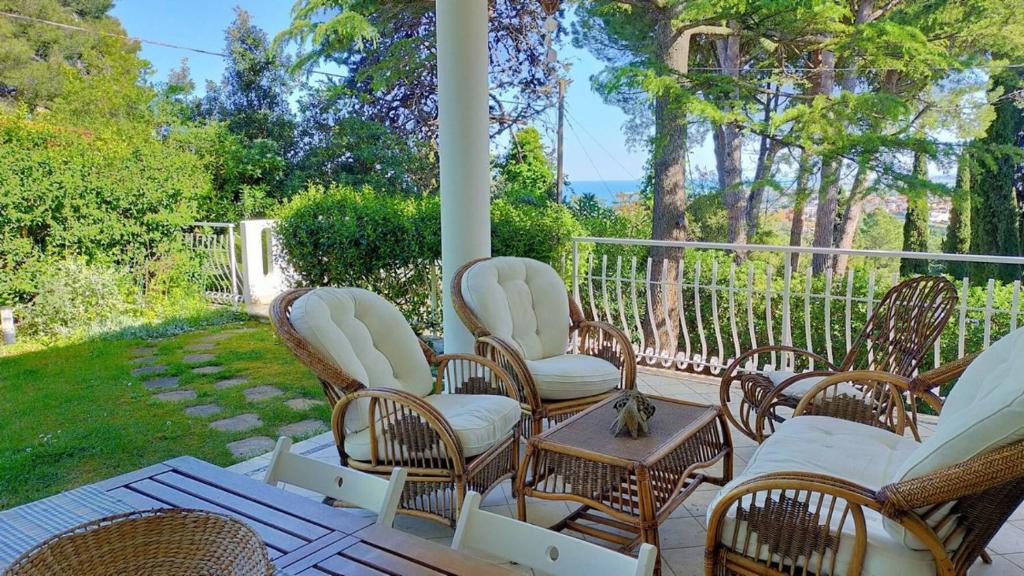 a porch with wicker chairs and a table at Villa Girasoli - Taunus Vacanze in Numana