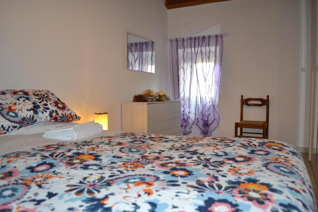 1 dormitorio con 1 cama con edredón de flores en Casa Vacanza Palazzo la Loggia, en Barisciano