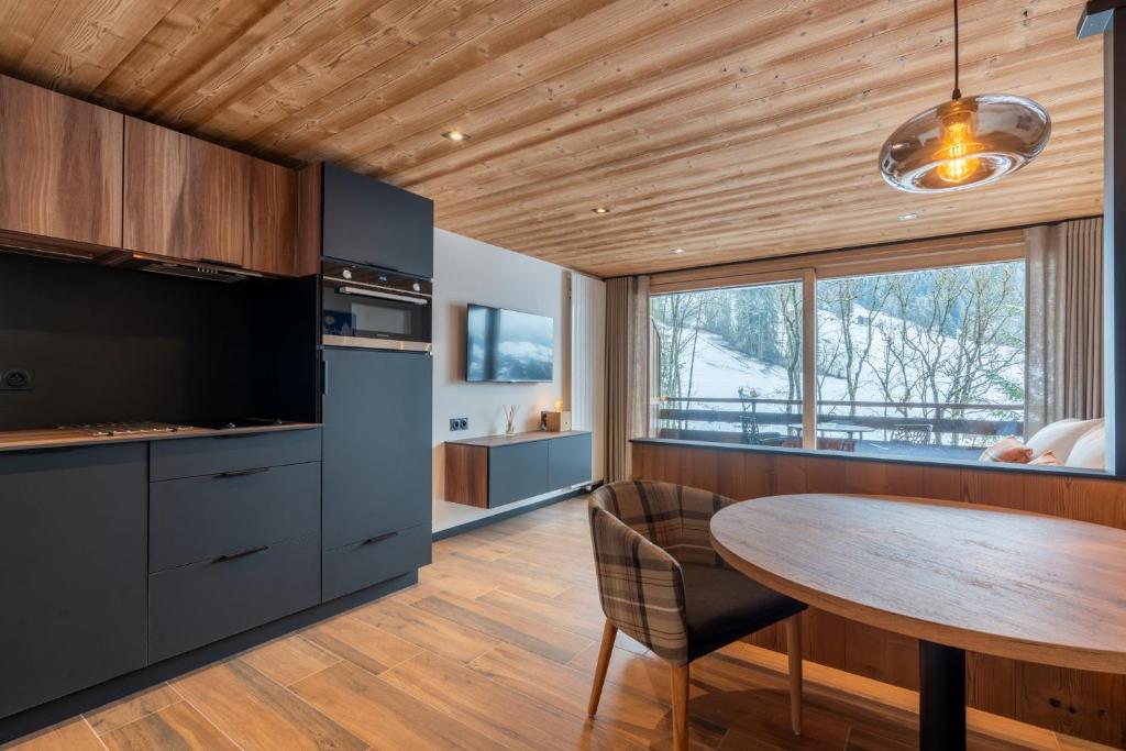 a kitchen with a wooden ceiling and a wooden table at TARDEVANT 21 in Le Grand-Bornand