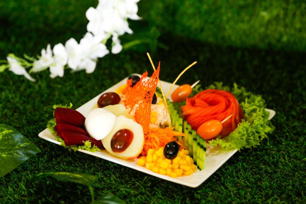 a plate of food with vegetables on the grass at Complexe El Bassatine in Beni Mellal
