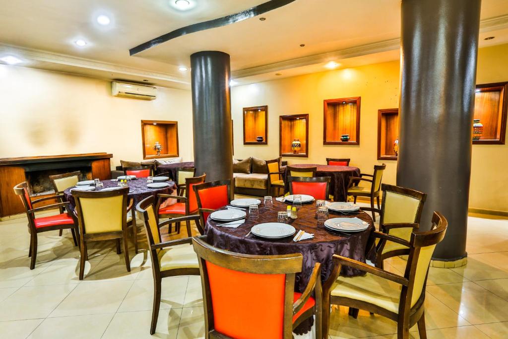 a restaurant with tables and chairs and a fireplace at Complexe El Bassatine in Beni Mellal