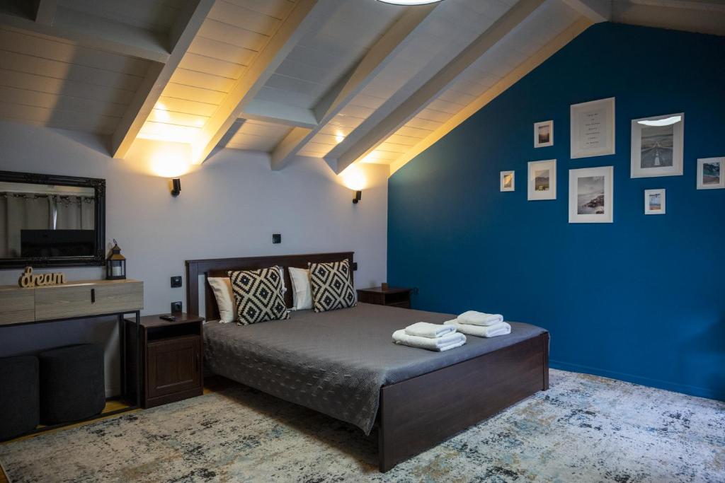 a bedroom with a bed and a blue wall at Deisisroom nafplio poseidon in Nafplio