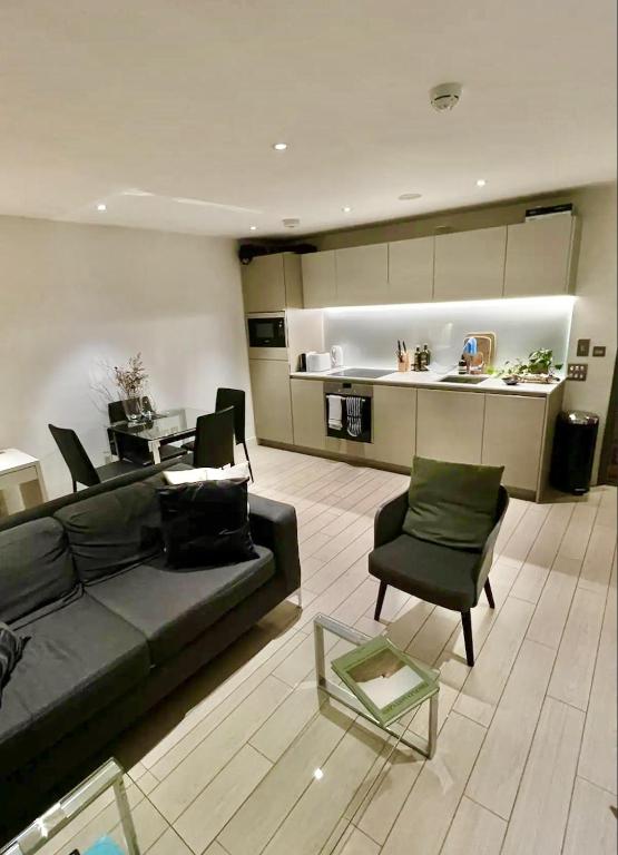 a living room with a black couch and a table at Trendy & Chic Apartment In The Heart of London in London