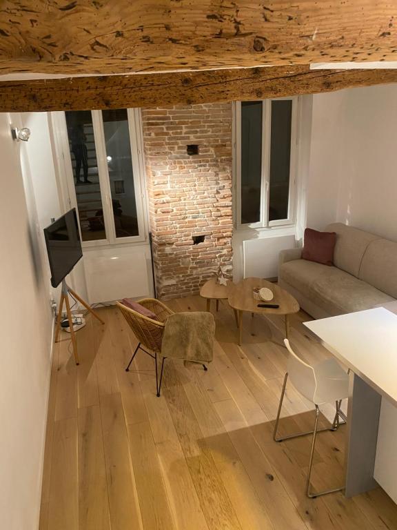un salon avec un canapé et une table dans l'établissement Duplex aux Carmes, à Toulouse