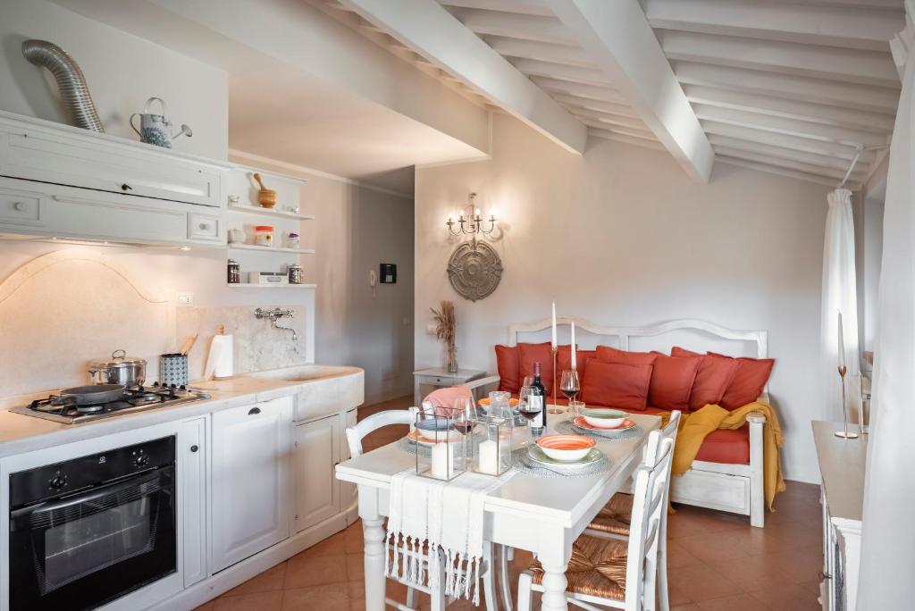 una cucina e un soggiorno con tavolo e sedie bianchi di Il Cantinone a San Vincenzo