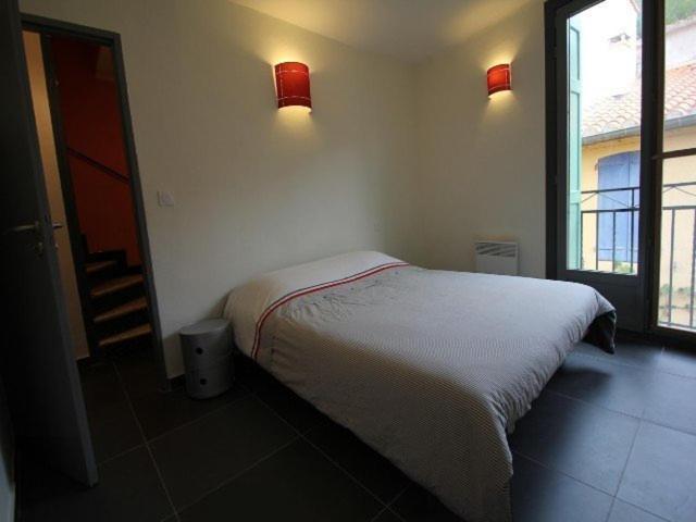 ein Schlafzimmer mit einem Bett und zwei Lampen an der Wand in der Unterkunft 4EGA41 Superbe F3 en duplex rénové - centre ville in Collioure