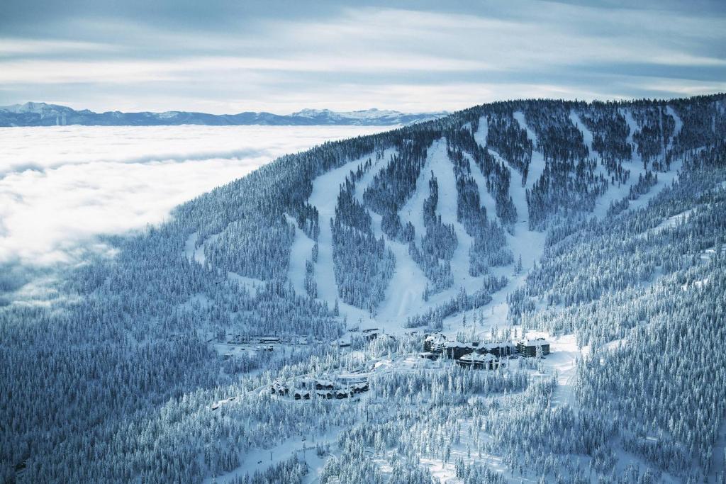 una vista aérea de una montaña cubierta de nieve y árboles en The Ritz-Carlton, Lake Tahoe, en Truckee