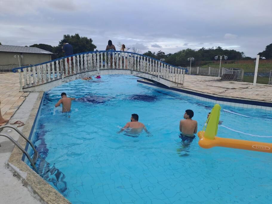 eine Gruppe von Personen, die in einem Schwimmbad schwimmen in der Unterkunft Sítio Meu Refúgio in Cabo Frio