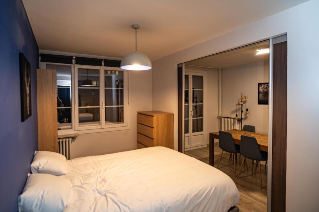- une chambre avec un lit et une table avec des chaises dans l'établissement Joli T2 proche du métro avec vue Tour Eiffel, à Issy-les-Moulineaux