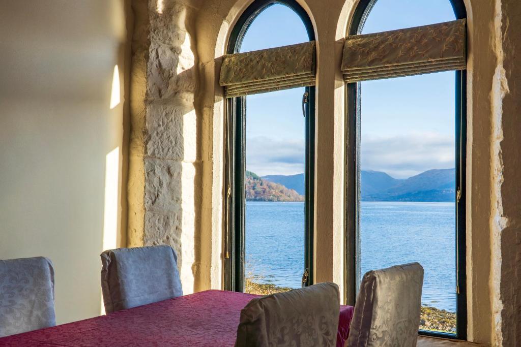 a room with a table and a view of the water at Newton Hall in Inveraray