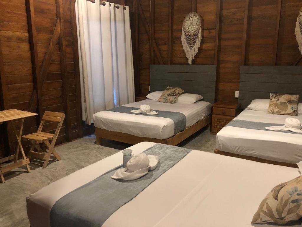 Habitación con 2 camas con sombreros encima en Cabañas Chac Mool en Holbox Island