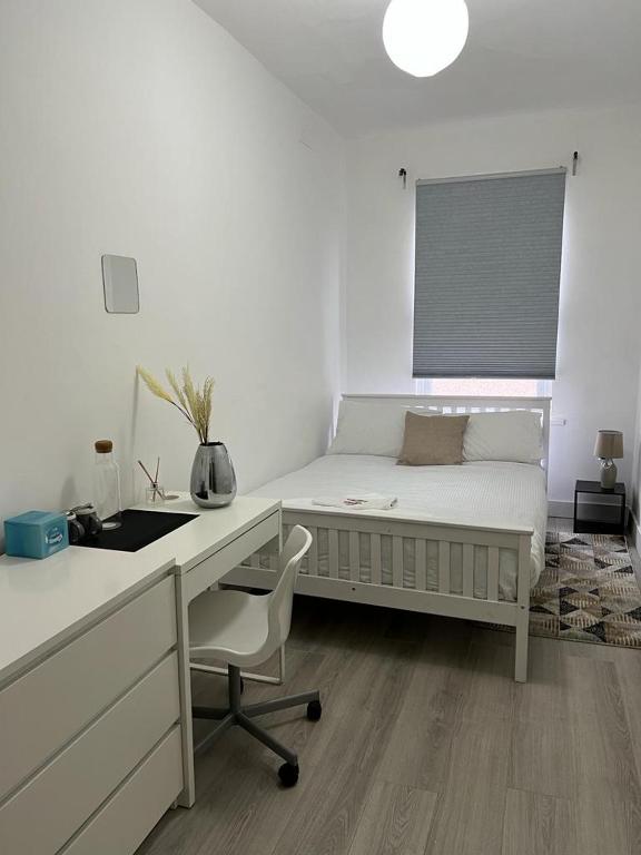 a white bedroom with a desk and a bed at Comfortably Spacious Cosy Double Bed Room located near City Centre, suitable for Contractors Health Care Professionals or long business stays in Coventry or delightful holidays in Coventry or within the West Midlands area Free Wifi Tea and Coffee Provided in Coventry