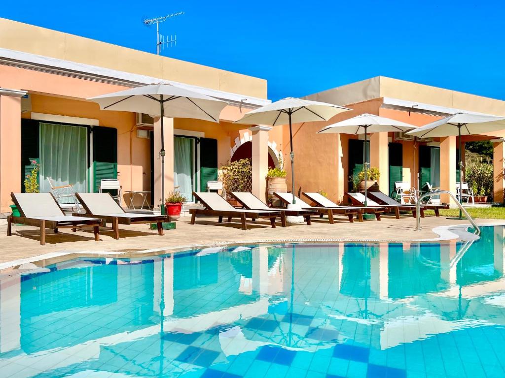 - une piscine avec des chaises et des parasols à côté d'un bâtiment dans l'établissement Villa Bougarini with private pool by DadoVillas, à Velonádes
