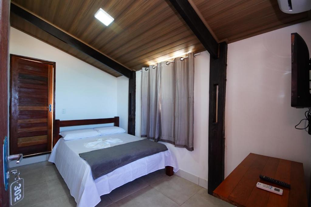 a small bedroom with a bed and a window at Pousada Girassol in Maceió