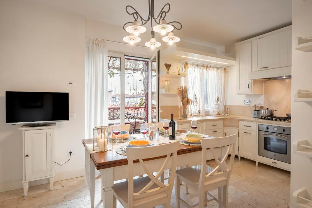 cocina con mesa y sillas y TV en Corso Emanuele Apartments, en San Vincenzo