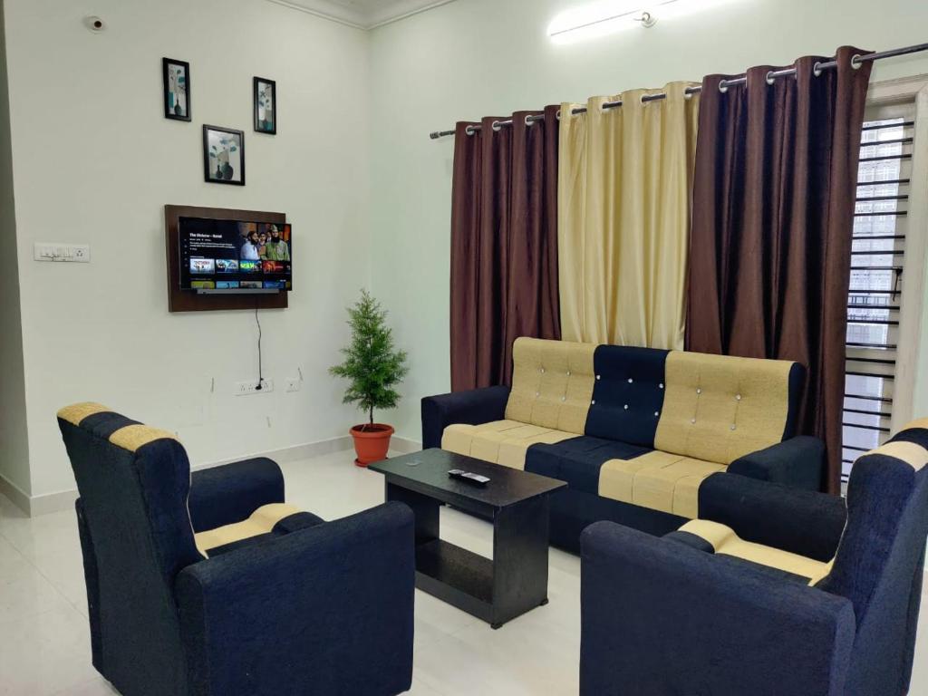 a living room with a couch and two chairs at Galaxy Villa's Homestay 8431o31389 in Mysore