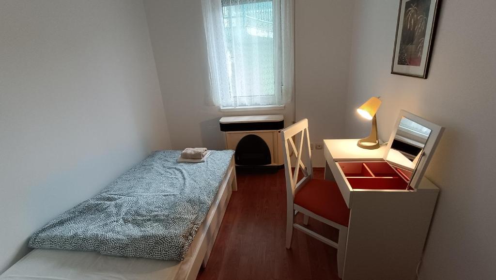 - une chambre avec un lit, un bureau et une fenêtre dans l'établissement Apartman Anja, 
