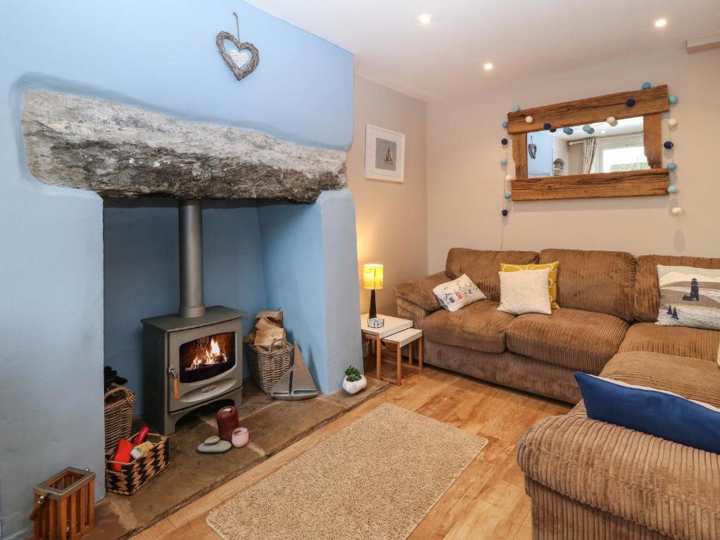 a living room with a couch and a fireplace at Dolafon in Pwllheli
