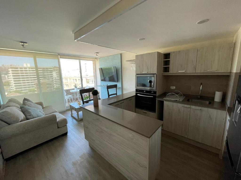 a kitchen and living room with a couch and a table at Arriendo Departamento 10 Norte Viña del Mar in Viña del Mar