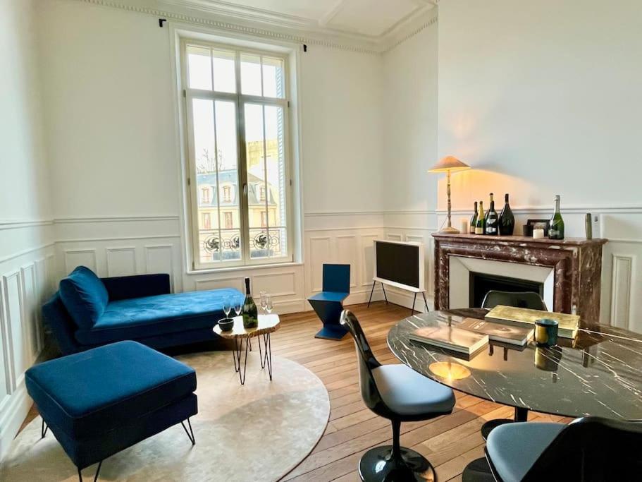 sala de estar con sofá azul y mesa en Champagne des Anges - Proche Cathédrale de Reims, en Reims