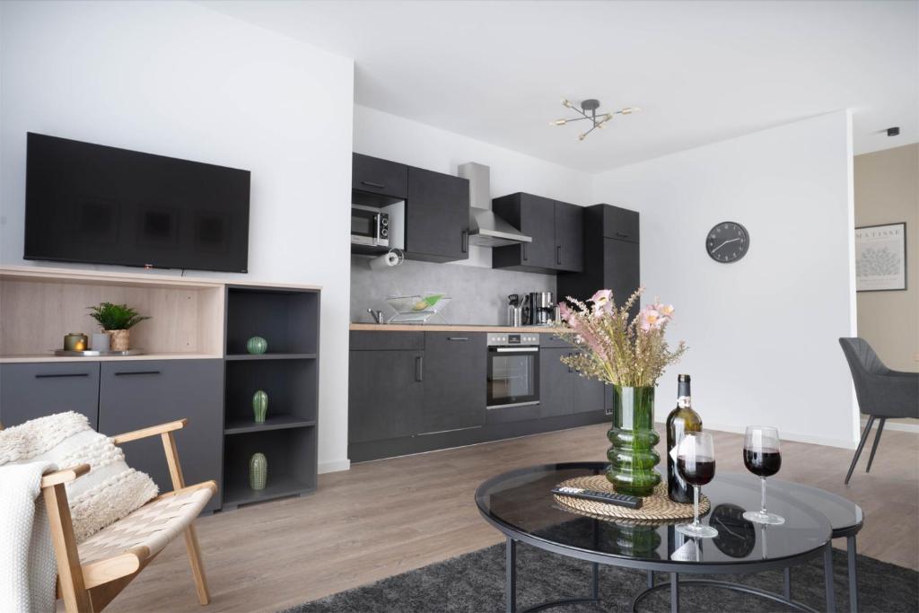 uma sala de estar com uma mesa e uma cozinha em Schicke Apartments in Osnabrück I private Parkplätze I home2share em Osnabrück