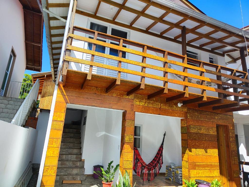 une maison avec une terrasse en bois au-dessus dans l'établissement Casas do juju, à Palhoça