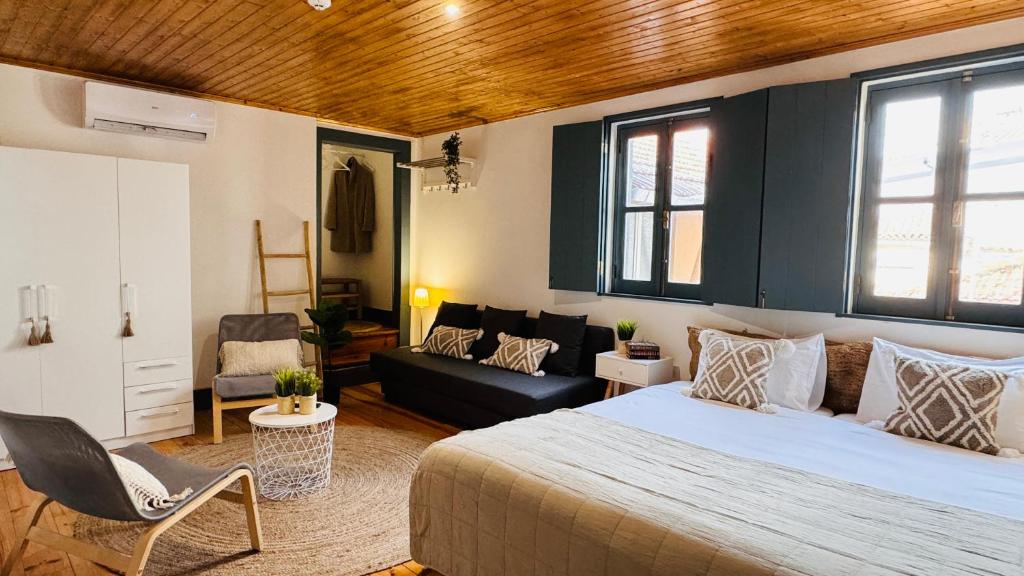 um quarto com uma cama e uma sala de estar em Sé Velha Suites em Coimbra