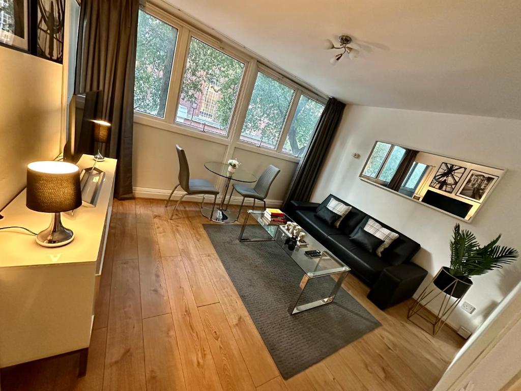 een woonkamer met een bank en een tafel bij Cosy Central London Apartment in Londen
