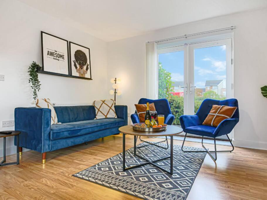 una sala de estar con 2 sofás azules y una mesa. en Stylish City Centre Apartment with Free Parking, Fast W-fi, Smart TV and Balcony by Yoko Property, en Chelmsford