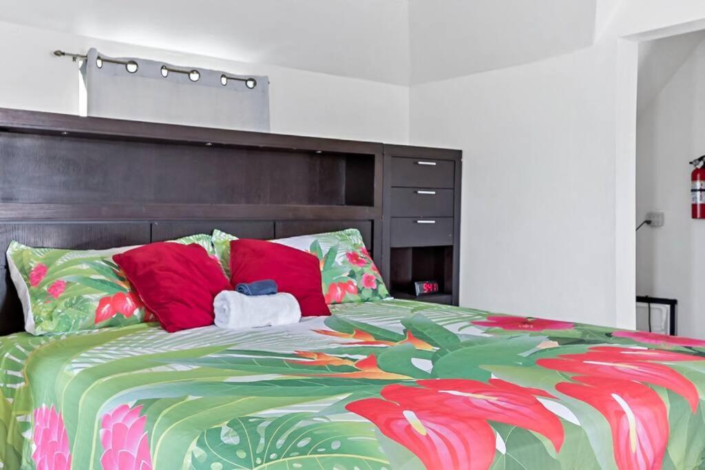 a bedroom with a large bed with red pillows at Cocoplum Rest N Hideaway #2 in Nassau